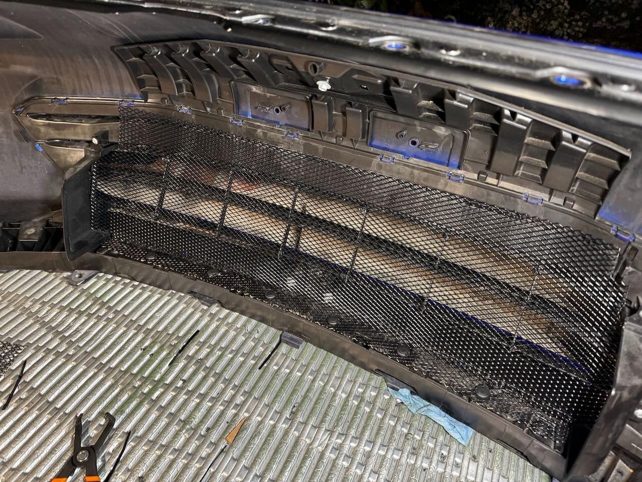 Grill installed before bumper is reinstalled. Notice 6 pop clips on the bottom edge and zip ties in the middle. The very top of the mesh will be sandwiched by the bumper crash foam.